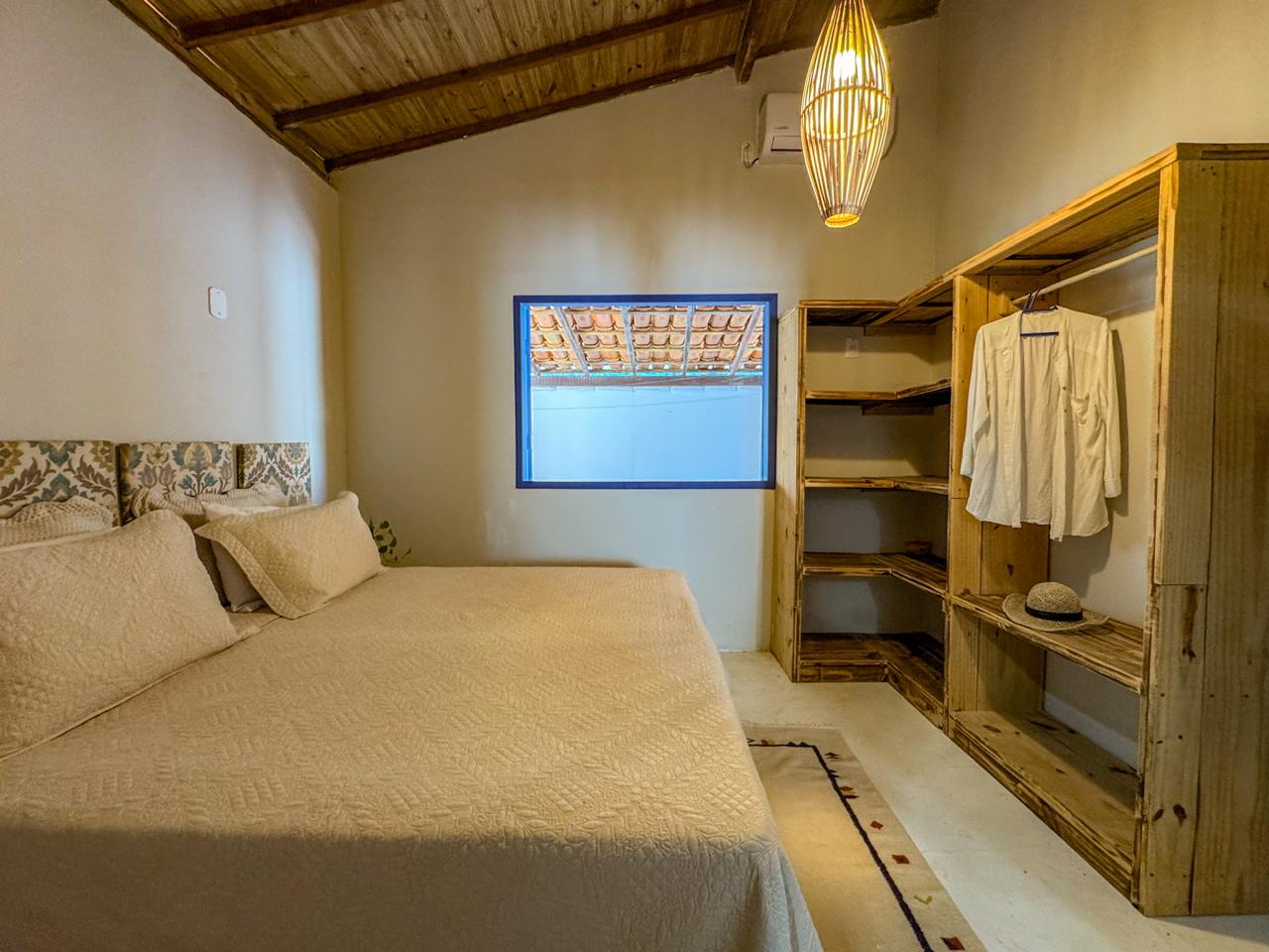 Quarto com armário aberto de madeira