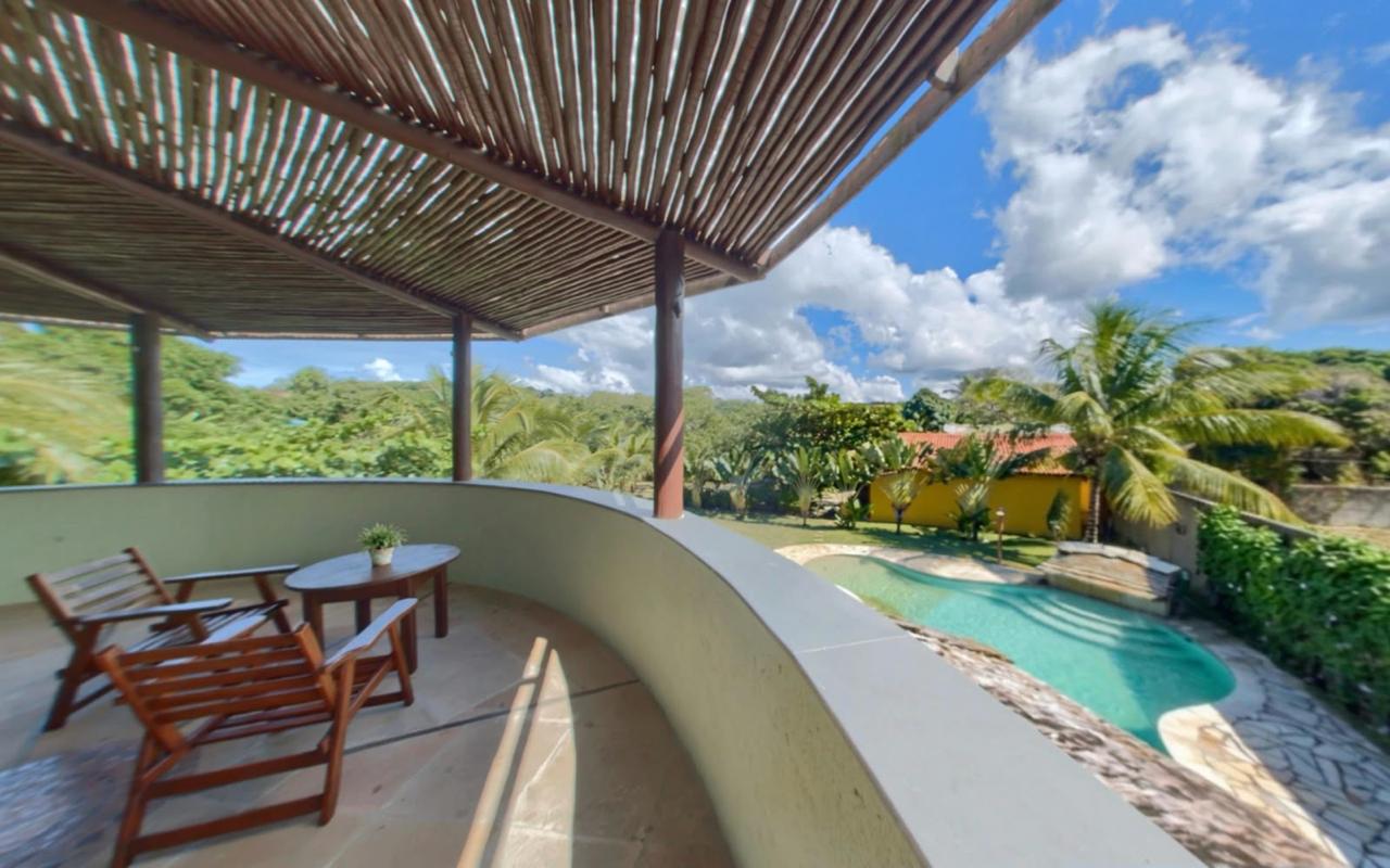 Varanda superior voltada para a piscina e o jardim